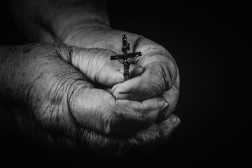 he cross is in the hands of the old man.