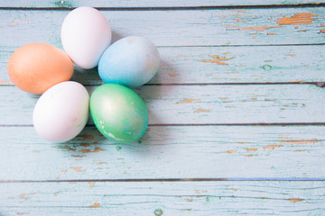 White, green, gold and blue easter eggs in form of flower on the blue wooden background