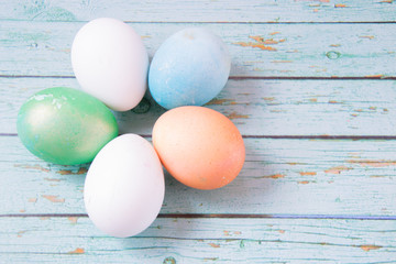 White, green, gold and blue easter eggs in form of flower on the blue wooden background