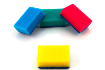 Четыре цветных поролоновых губки для мойки и чистки, уложенных по схеме три плюс один.