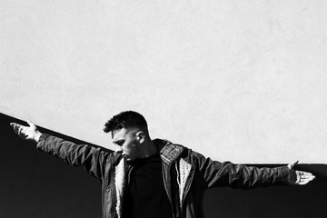 Pretty serious young man on the street. Casual Lifestyle clothes male model, posing on geometric...