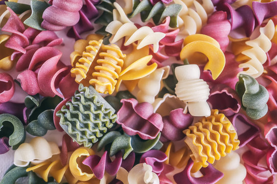Mixed selection of dried pasta on wooden background. Macaroni scattered on a glass jar. Background.