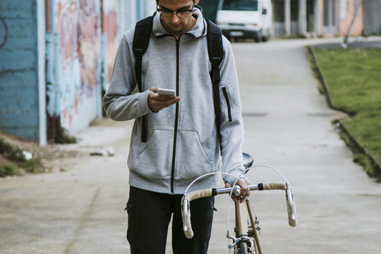 young in town with mobile phone and bike