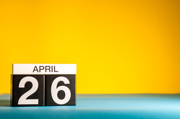 April 26th. Day 26 of april month, calendar on table with yellow background. Spring time, empty space for text