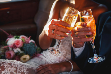 Young wedding holds and climb glasses of champagne