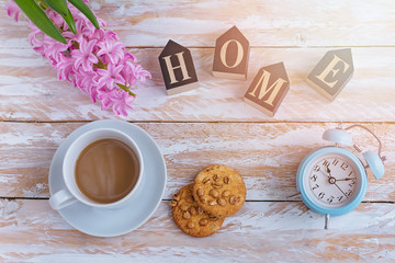Coffee in white cup and cookies on a white table and the white alarm clock the top view