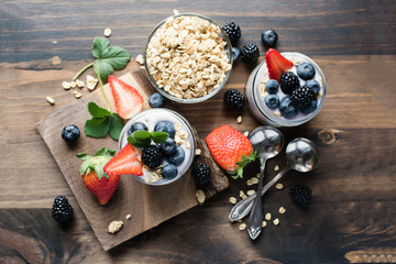 Yogurt and granola with berries, healthy cereal breakfast, toned image, selective focus