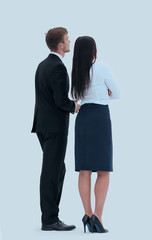 rear view. businessman and business woman standing next to and looking forward.