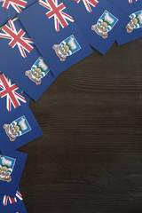 Falkland Islands small flags framing a wood texture background with copy space