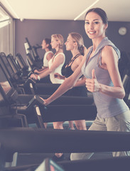 Fototapeta na wymiar Satisfied girls running on treadmills