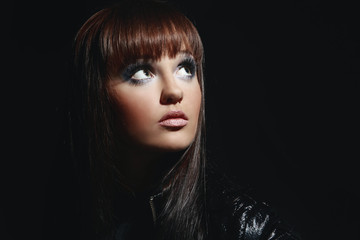 stylish young woman with evening makeup on a black background