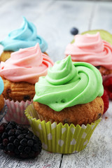 Tasty cupcakes on wooden background. Birthday cupcake in rainbow colors