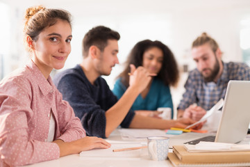 At office. Portrait of a young woman looking at the camera.