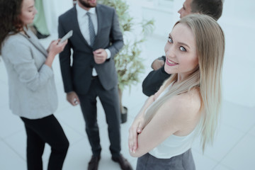 successful young woman - a company employee against the backdrop of colleagues