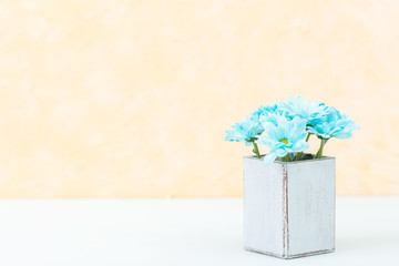 Pastel yellow vertical banner with beautiful bouquet of fresh blue chrysanthemum in retro shabby chic vase. Copyscape area.