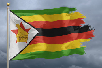 Zimbabwe flag weathered and torn with a cloudy sky