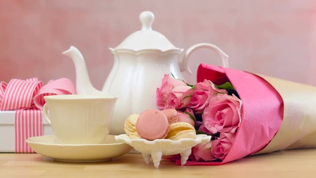 Mother's Day tea setting with teapot, macaron cookies, pink roses and gift.