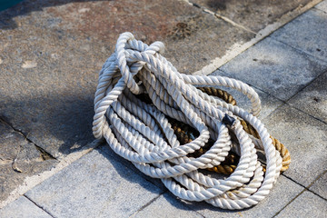 Fototapeta premium coiled rope on stone marina