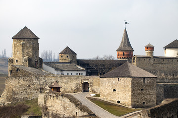 Fototapeta na wymiar Kamianets Podilskyi fortress built in the 14th century. View of the fortress wall with towers at early springtime, Ukraine