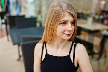 Close up portrait of blonde girl sitting on the mall.