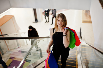 Girl with shopping bags in the mall at the escalator.