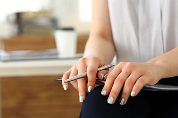 Female arm in suit hold silver pen