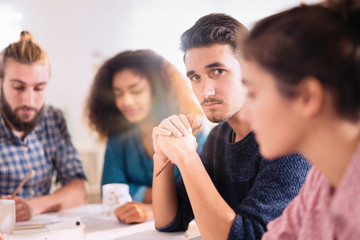 young man looking at the camera during a work meet
