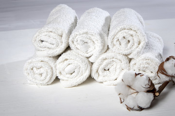 towel for hand in spa salon and a cotton branch on a white wooden table