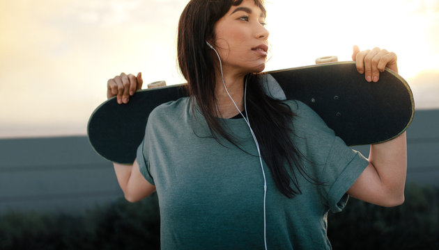 Attractive female skateboarder outdoors - Powered by Adobe