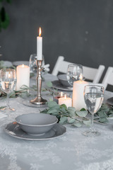 Wedding or festive table setting. Plates, wine glasses, candles and cutlery