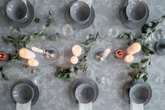 Wedding or festive table setting. Plates, wine glasses, candles and cutlery