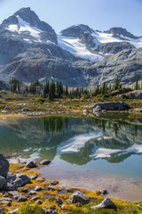 Face Mountain, glaciers and conifer tree reflections, Semaphore Lakes, Canada.