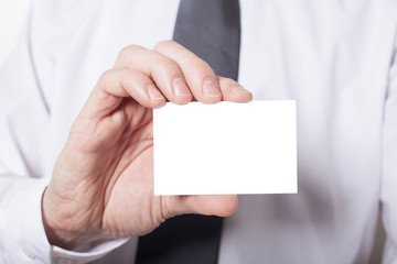 Geschäftsmann zeigt weiße Visitenkarte mit Textfreiraum