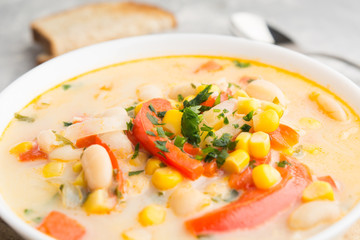 Cream soup with corn, beans, onion, pepper. Closeup view