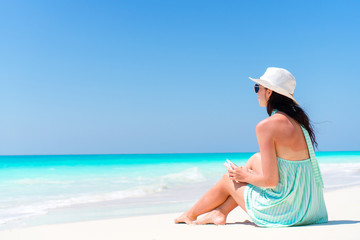 Fototapeta na wymiar Woman sitting on beach enjoying summer holidays