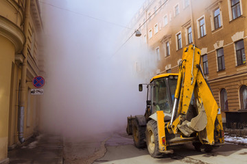 Fototapeta na wymiar The accident of hot water supply occurred on the city street and steam from hot water formed, the excavator is there for repair. St. Petersburg, Russia, repair of pipes in Stolyarny Lane