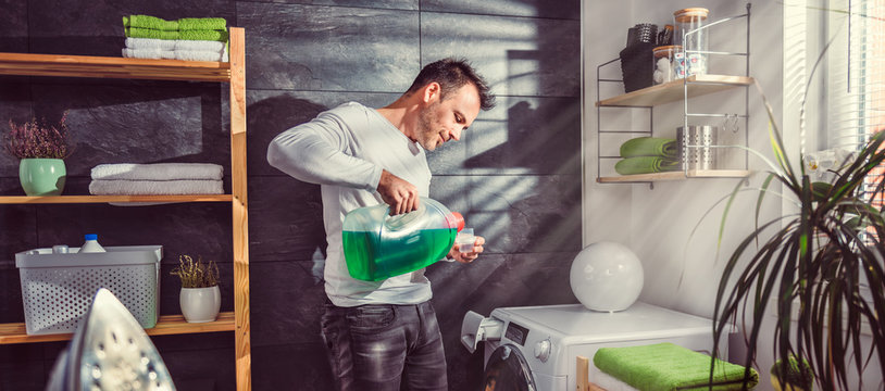 Man pouring liquid laundry detergent In the bottle cap