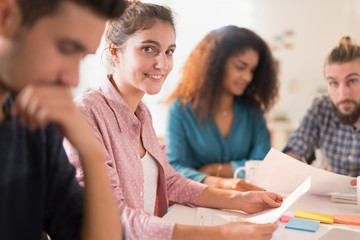 Portrait of a young woman looking at the camera during a meeting