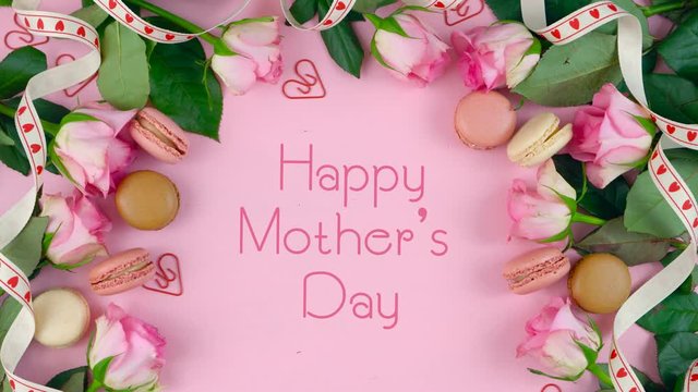 Happy Mother's Day background of pink roses and macaron cookies on pink wood tabl with animated text typography greeting.