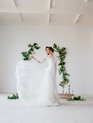 A young bride is whirling in a wedding dress.