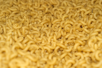 background - a pile of light yellow dry pasta on weight without packaging