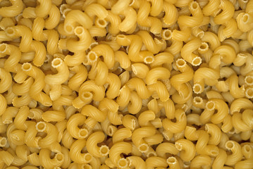 background - a pile of light yellow dry pasta on weight without packaging
