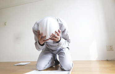 設計図面を見て頭を抱える男性