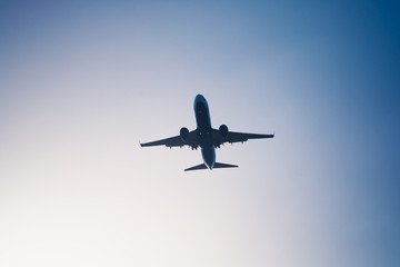 Fototapeta na wymiar flying airplane silhouette in blue sky dusk