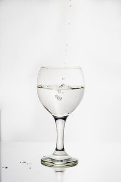 Ett glas i silhuett fylls med p&auml;rlande och friskt vatten