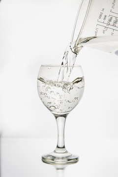 Ett glas i silhuett fylls med pärlande och friskt vatten