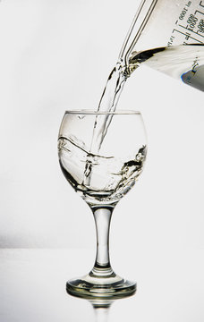 Ett glas i silhuett fylls med p&auml;rlande och friskt vatten