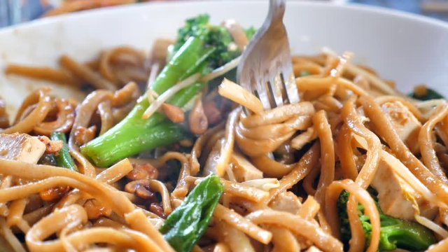 Slow motion (60fps) - Fork spinning and picking up Noodles out of a hot Thai dish. 