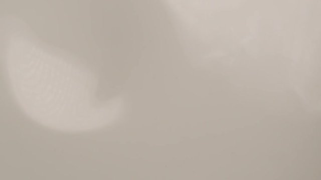 Beauty cream droplet super slow motion. Macro shot of milk dropping in super slow motion