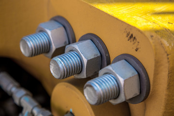 Machine part joint by bolts and nuts. Close-up view